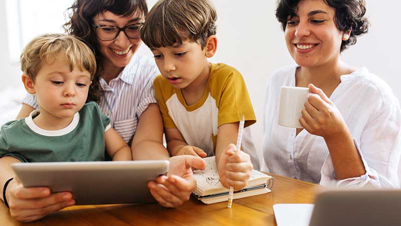 Medienerziehung in der Familie - Kinder schauen mit Eltern auf Tablet