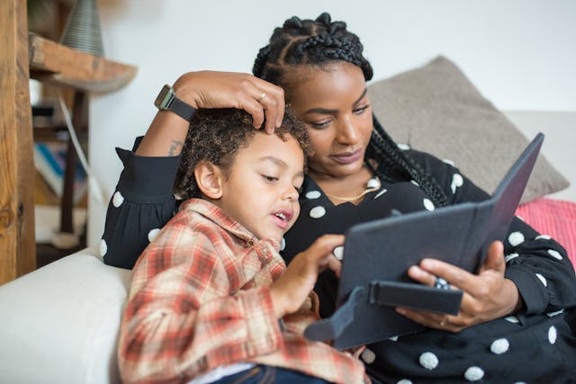 Medienerziehung in der Familie - Kinder schauen mit Eltern auf Tablet